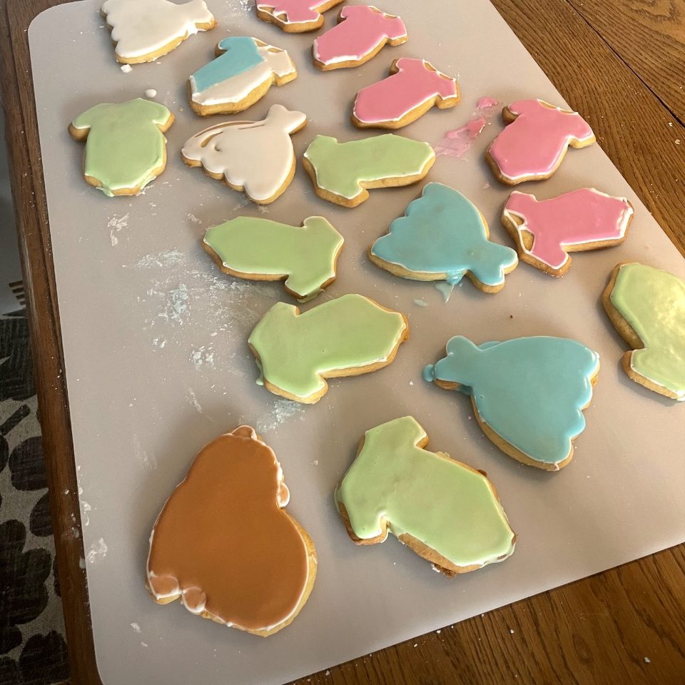 ateliers culinaires patisserie décoration de biscuits Gâteaux aux formes variées, décorés de glaçage coloré sur une surface de travail.