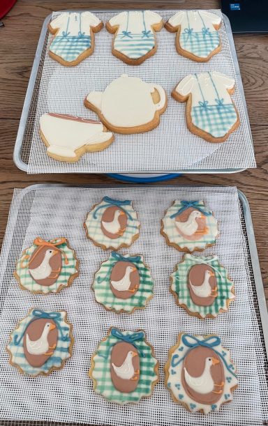 Biscuits décorés Biscuits décorés en forme de théières, tasses et oiseaux sur des grilles de refroidissement.