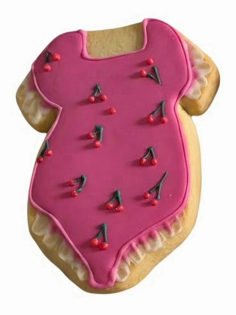Biscuit robe rouge biscuit anniversaire Gâteau en forme de robe, glacé en rose avec des décorations de cerises.